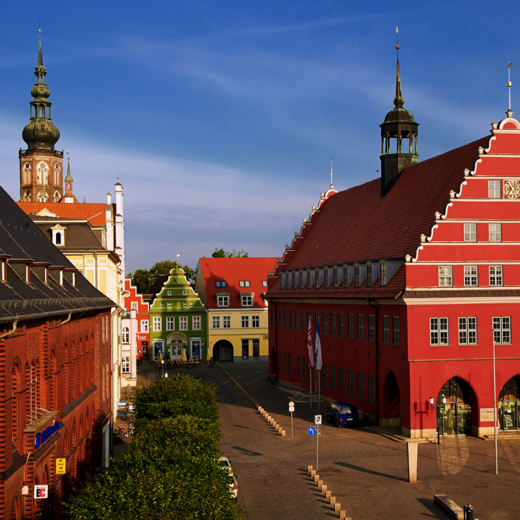 Häuserfassaden des Rathauses und der alten Post am  Greifswalder Marktplatz mit dem Dom im Hintergrund 