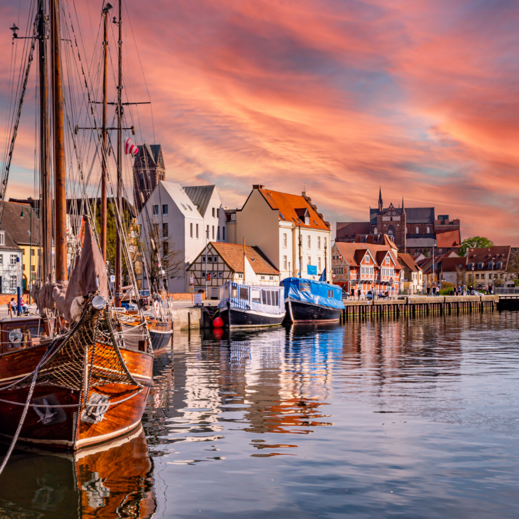 Der Wismarer Hafen bei Sonnenuntergang, mit Häuserfassaden im Hintergrund mit dem Hinweis Gewerbeanmeldung in Mecklenburg-Vorpommern