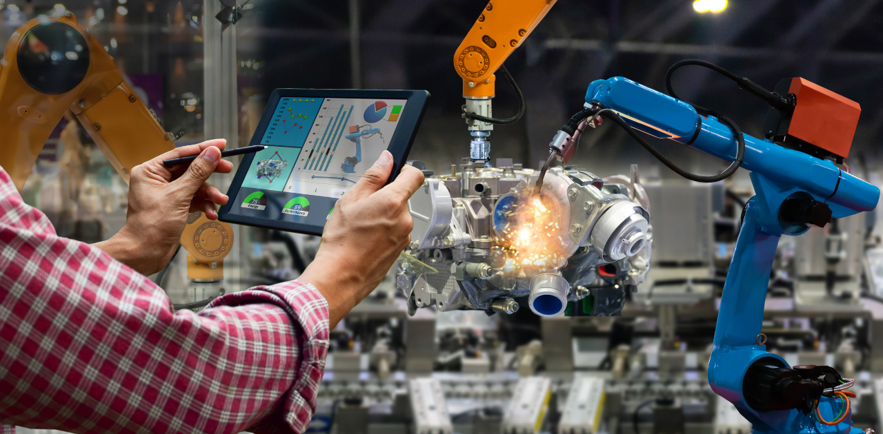 Symbolbild für Gemeinschaftsdiagnose: eine Person im Vordergrund hält ein Tablet mit Diagrammen, im Hintergrund ein Schweißroboter in einer Fertigungshalle