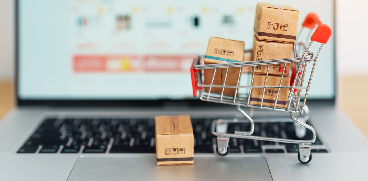 Symbolbild für Online-Handel: ein Spielzeugeinkaufswagen mit Paketen steht auf der Tastatur eines Notebooks