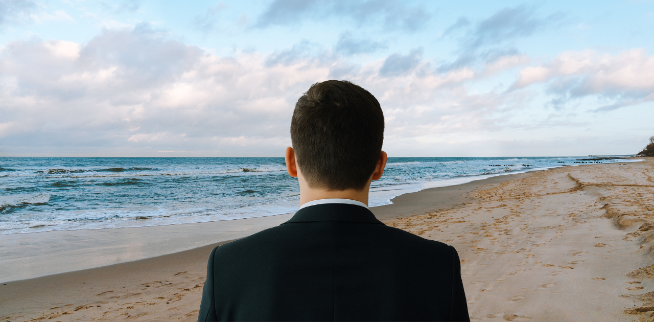 Person am Strand, blickt auf das Meer – symbolische Darstellung für Zukunftsplanung und Altersvorsorge.