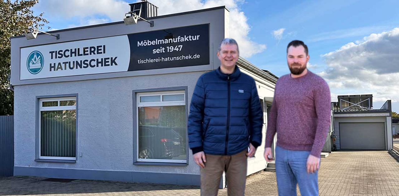 Zwei Personen stehen vor dem Gebäude der Tischlerei Hatunschek in Grimmen mit Firmenschild „Möbelmanufaktur seit 1947“ – Beispiel für eine erfolgreiche Tischlerei‑Nachfolge in MV.