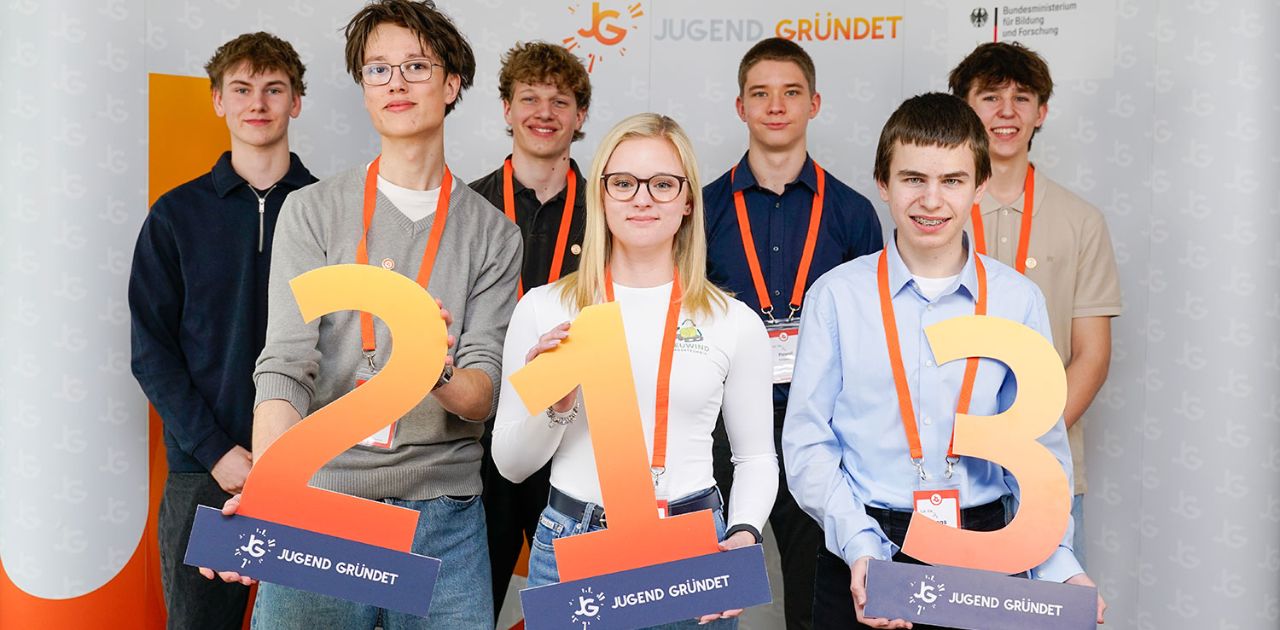 Schüler pitchen Geschäftsideen beim Wettbewerb Jugend gründet und zeigen die Auszeichnungen für Platz eins, zwei und drei beim Pitch Event in Berlin.
