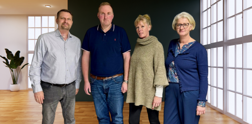 Gruppenfoto von Daniel Schulze, Andreas Heitmann, Anja Schimborski und Kathleen Meerkatz im Innenraum eines modernen Raums, aufgenommen im Rahmen des Generationswechsels in der Logistikbranche bei der TSU Bode GmbH.